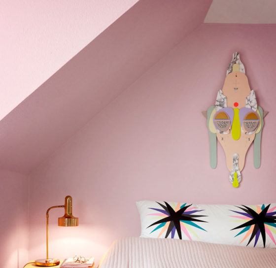 rosa farvet soveværelse med multifarve collage art maske hængende